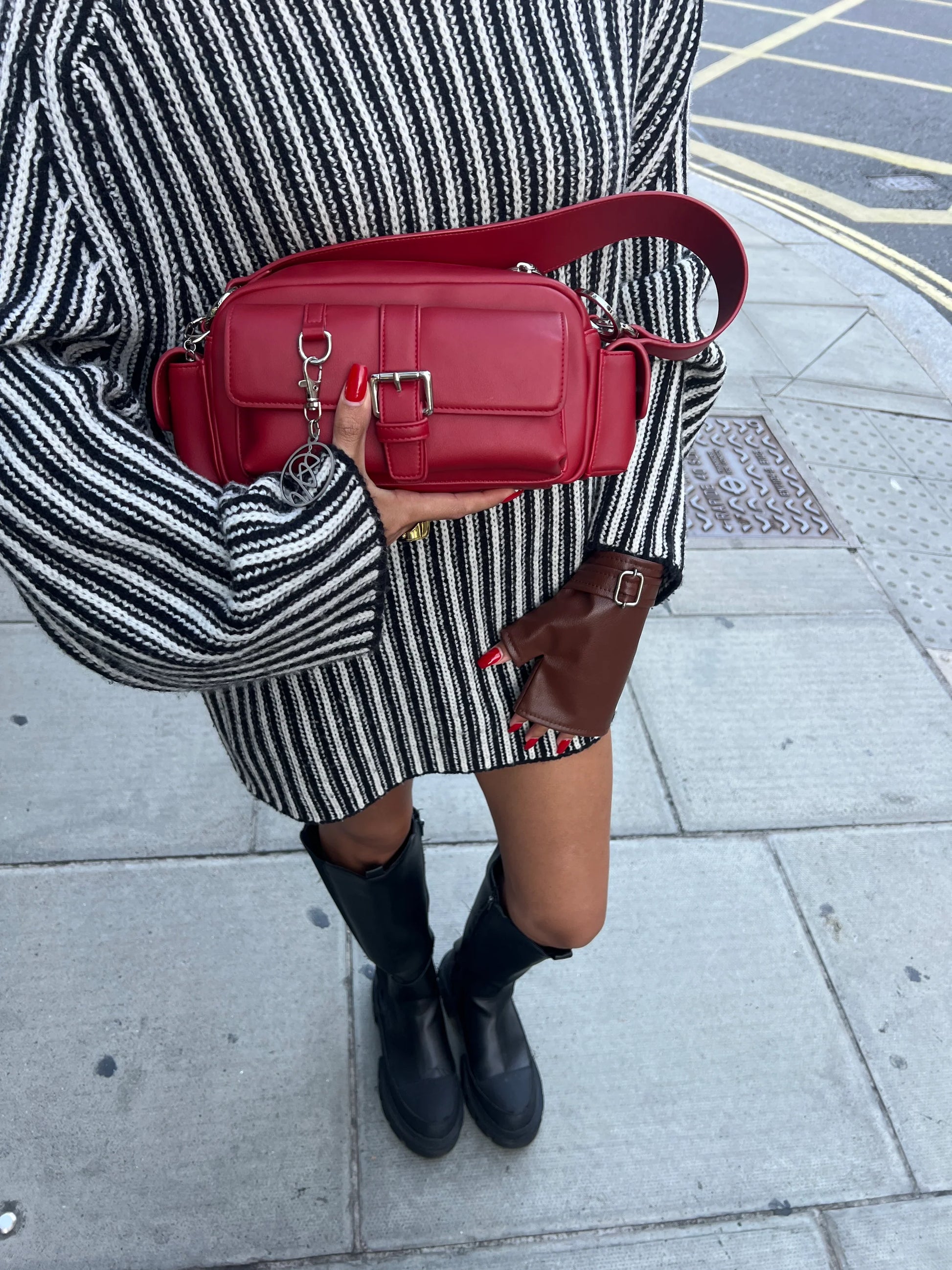 Accessible shoulder bag carried by hand as part of an everyday outfit