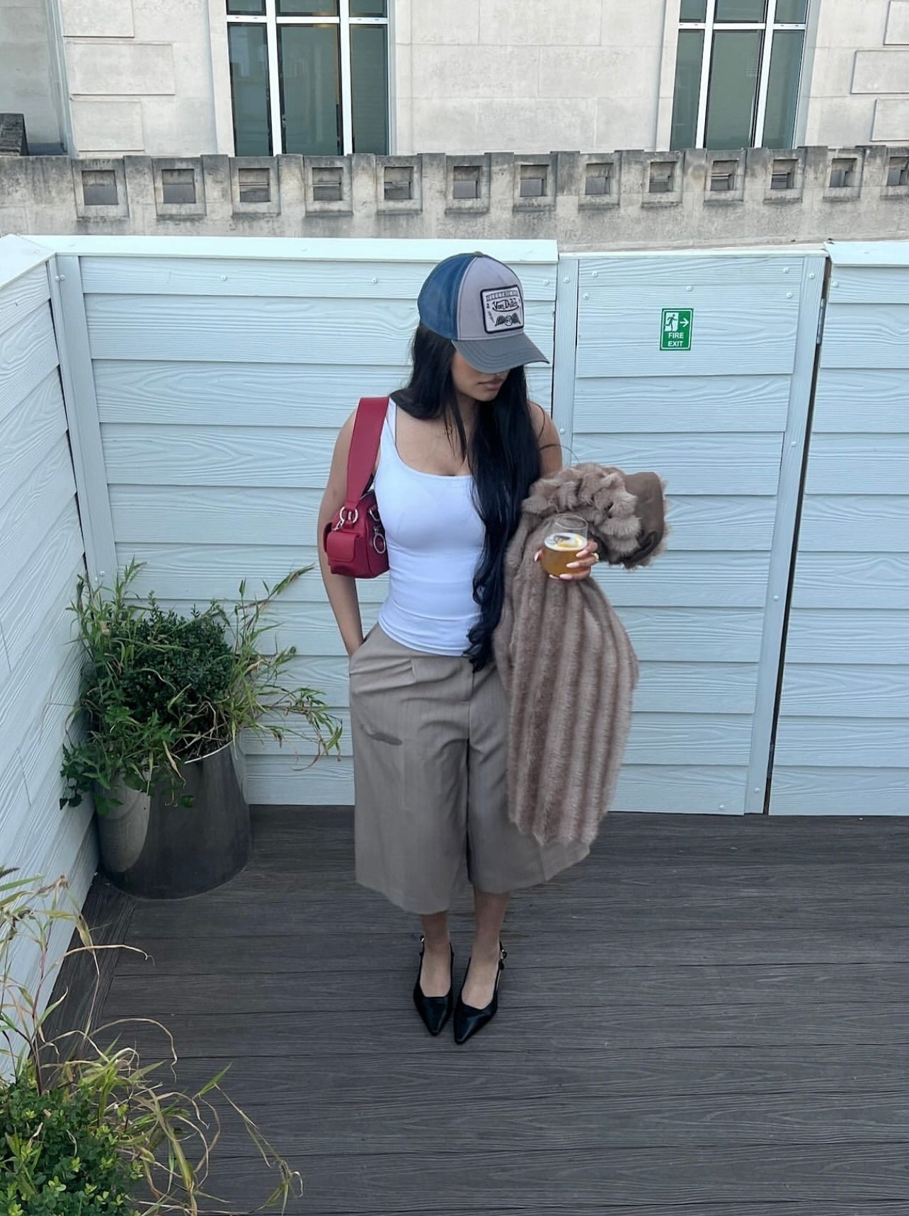 Woman wearing accessible shoulder bag on the shoulder in burgundy patent-finish PU leather